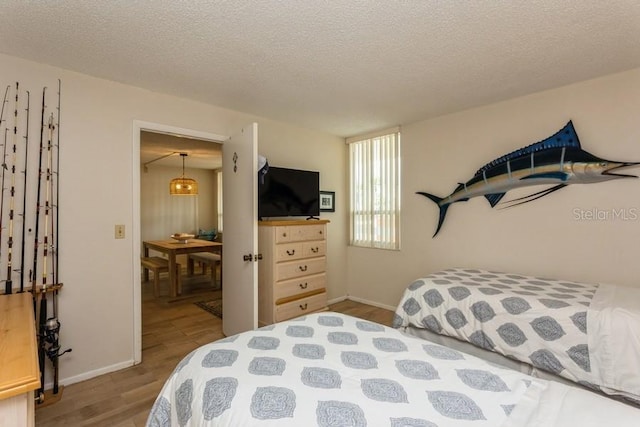 17900 Gulf Blvd Unit 1B, Redington Shores, FL 33708 - bedroom with wood finished floors, a textured ceiling, and baseboards