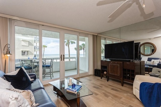 17900 Gulf Blvd Unit 1B, Redington Shores, FL 33708 - living room with light wood-style floors, a ceiling fan, and a textured ceiling