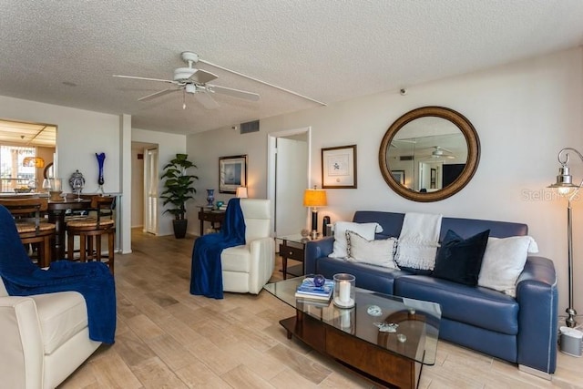 17900 Gulf Blvd Unit 1B, Redington Shores, FL 33708 - living area with light wood-style floors, a ceiling fan, and a textured ceiling
