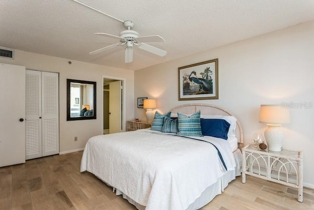 17900 Gulf Blvd Unit 1B, Redington Shores, FL 33708 - bedroom with wood finished floors, baseboards, a closet, a ceiling fan, and a textured ceiling