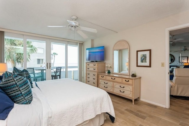 17900 Gulf Blvd Unit 1B, Redington Shores, FL 33708 - bedroom featuring access to outside, light wood-style flooring, multiple windows, baseboards, and a textured ceiling