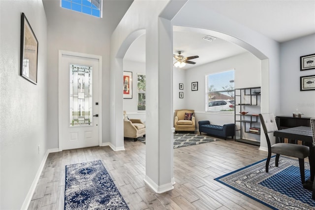 3046 Donington Castle Ln, Land O Lakes, FL 34638 - foyer entrance with light wood-style flooring, a ceiling fan, arched walkways, and baseboards
