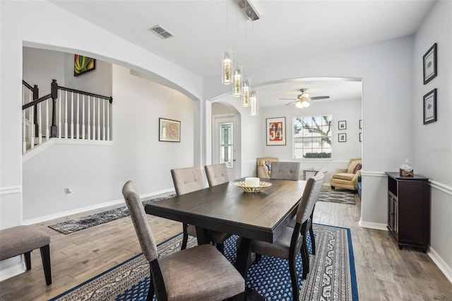 3046 Donington Castle Ln, Land O Lakes, FL 34638 - dining room featuring arched walkways, ceiling fan, light wood-type flooring, and baseboards