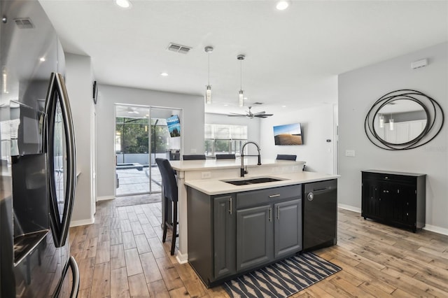 3046 Donington Castle Ln, Land O Lakes, FL 34638 - kitchen featuring stainless steel refrigerator with ice dispenser, a sink, dishwasher, light wood finished floors, and light countertops