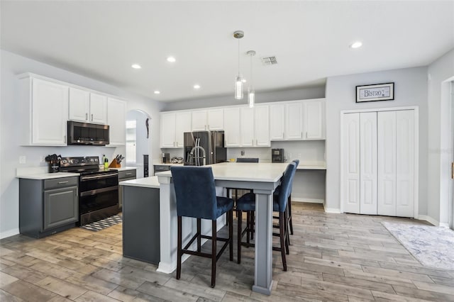 3046 Donington Castle Ln, Land O Lakes, FL 34638 - kitchen featuring stainless steel appliances, light countertops, light wood-type flooring, recessed lighting, and decorative light fixtures