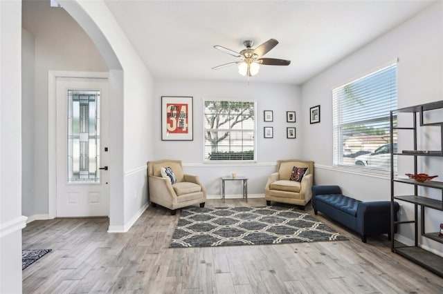 3046 Donington Castle Ln, Land O Lakes, FL 34638 - sitting room featuring arched walkways, a ceiling fan, wood finished floors, and baseboards