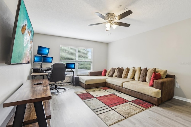 3046 Donington Castle Ln, Land O Lakes, FL 34638 - living area with a desk, wood finished floors, ceiling fan, and baseboards