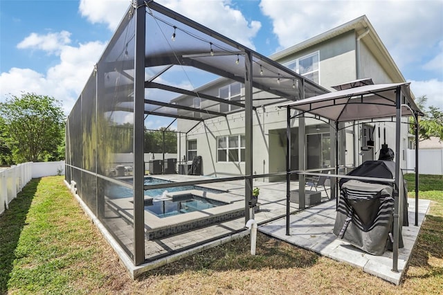 3046 Donington Castle Ln, Land O Lakes, FL 34638 - back of property featuring a patio area, stucco siding, an in-ground hot tub, a lanai, and fence