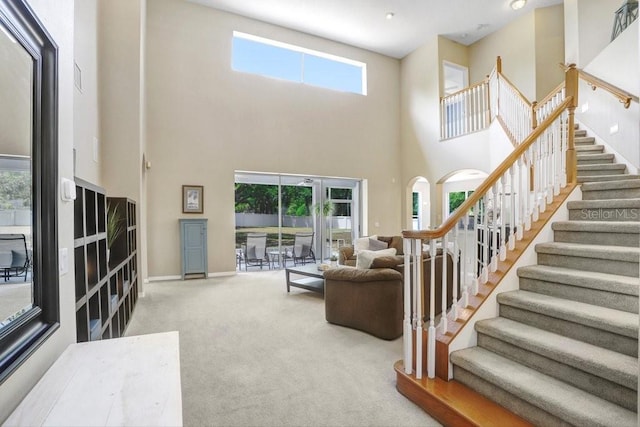 808 Hickory Glen Dr, Seffner, FL 33584 - carpeted living room featuring healthy amount of natural light, stairway, and a towering ceiling
