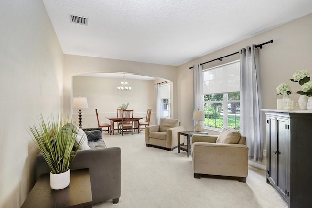 808 Hickory Glen Dr, Seffner, FL 33584 - living area featuring arched walkways, light colored carpet, and a chandelier