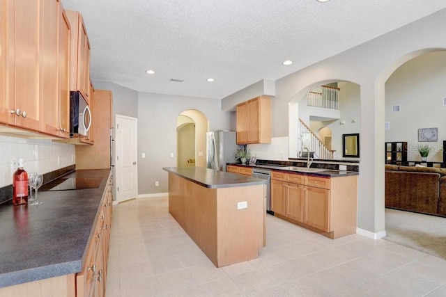 808 Hickory Glen Dr, Seffner, FL 33584 - kitchen with stainless steel appliances, dark countertops, a center island, tasteful backsplash, and a textured ceiling
