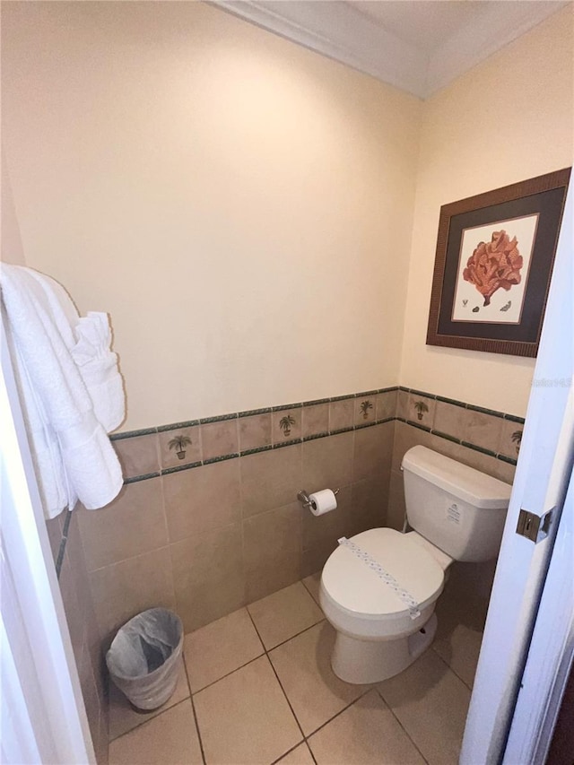 7673 Heritage Crossing Way Unit 202, Reunion, FL 34747 - bathroom featuring toilet, tile walls, wainscoting, and tile patterned flooring