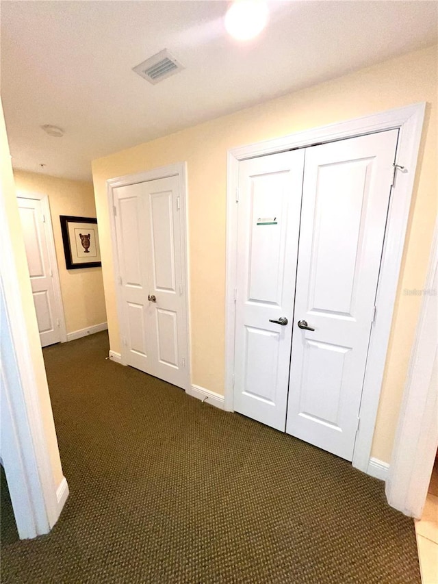 7673 Heritage Crossing Way Unit 202, Reunion, FL 34747 - hall with baseboards, visible vents, and dark colored carpet
