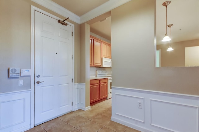 corridor featuring light tile patterned floors, a decorative wall, and wainscoting