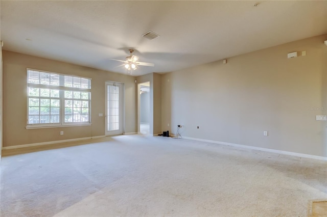carpeted empty room with a ceiling fan, baseboards, and visible vents