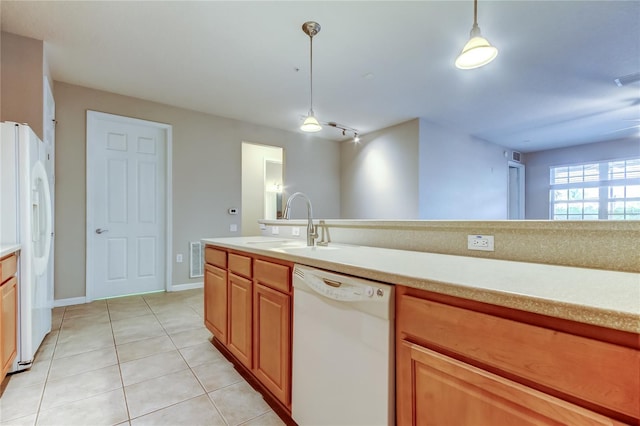 kitchen featuring pendant lighting, white appliances, light countertops, a sink, and light tile patterned floors