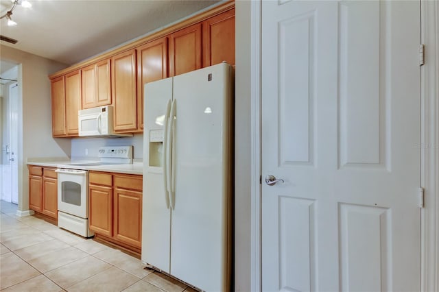 kitchen with light countertops, light tile patterned floors, and white appliances