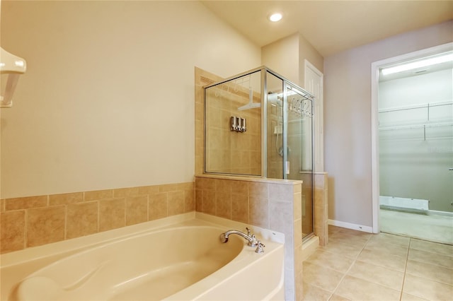 full bath featuring a walk in closet, a garden tub, a stall shower, tile patterned floors, and recessed lighting