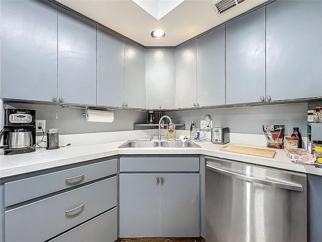 kitchen featuring a sink, light countertops, gray cabinets, and dishwasher