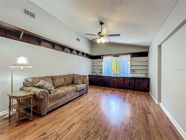 living area with visible vents, wood finished floors, ceiling fan, a textured ceiling, and vaulted ceiling