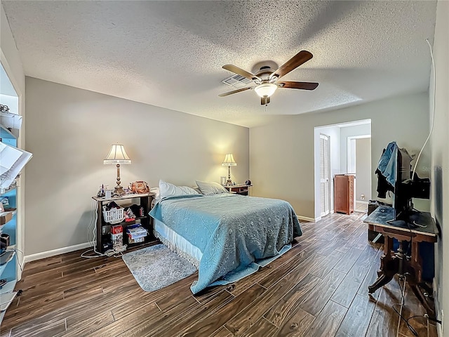 bedroom featuring a textured ceiling, baseboards, and wood tiled floor