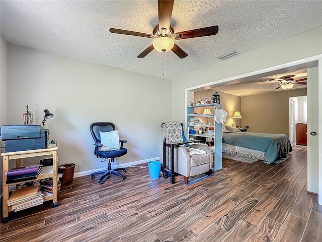 bedroom featuring baseboards, wood tiled floor, a textured ceiling, and visible vents