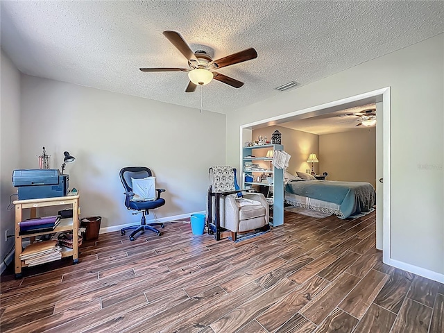 bedroom featuring a ceiling fan, a textured ceiling, visible vents, wood finished floors, and baseboards