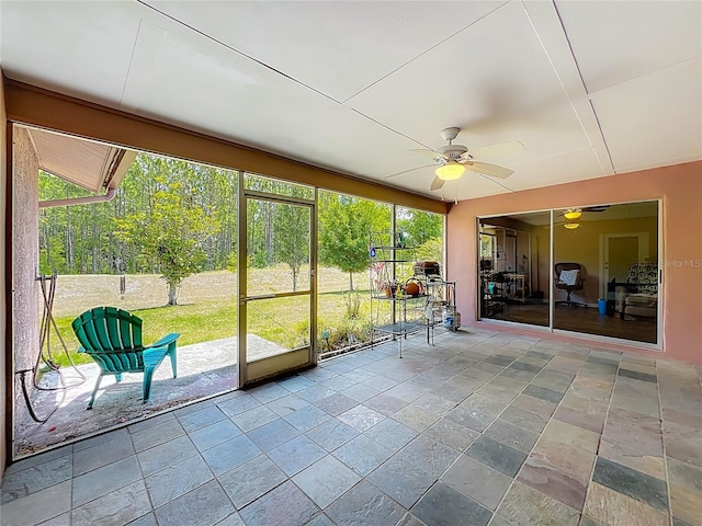 unfurnished sunroom with ceiling fan