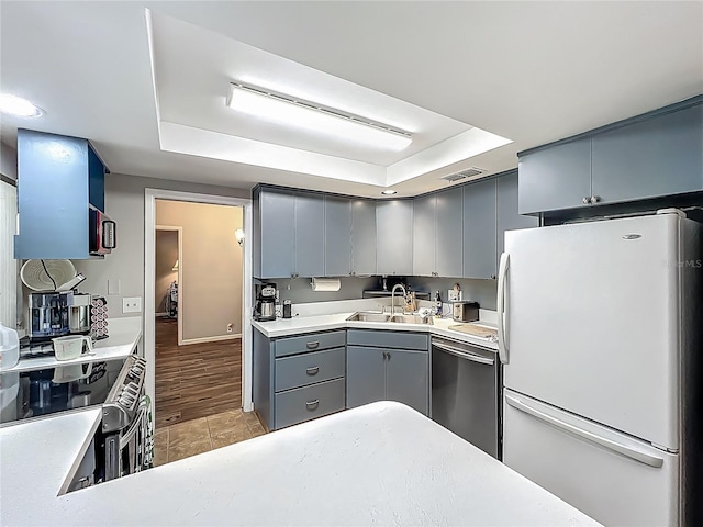 3932 Watson Dr, New Port Richey, FL 34655 - kitchen featuring freestanding refrigerator, gray cabinets, visible vents, a raised ceiling, and dishwasher