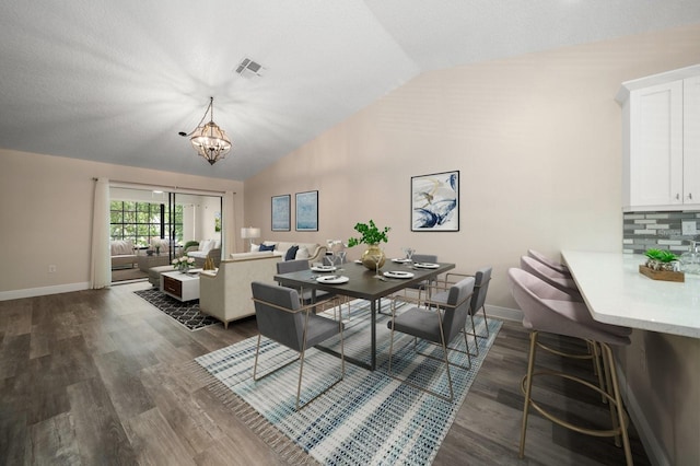 2170 Elm St Unit 906, Dunedin, FL 34698 - dining room with visible vents, dark wood finished floors, lofted ceiling, and a notable chandelier