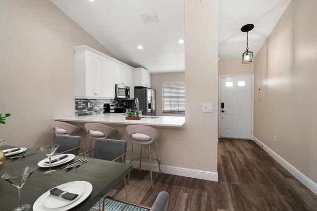 2170 Elm St Unit 906, Dunedin, FL 34698 - kitchen with tasteful backsplash, a sink, dark wood finished floors, appliances with stainless steel finishes, and vaulted ceiling
