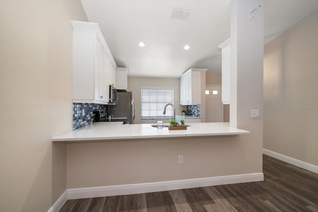 2170 Elm St Unit 906, Dunedin, FL 34698 - kitchen featuring visible vents, tasteful backsplash, baseboards, a peninsula, and dark wood-type flooring