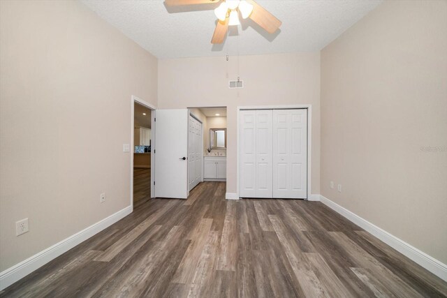 2170 Elm St Unit 906, Dunedin, FL 34698 - unfurnished bedroom featuring baseboards, dark wood finished floors, visible vents, and a towering ceiling