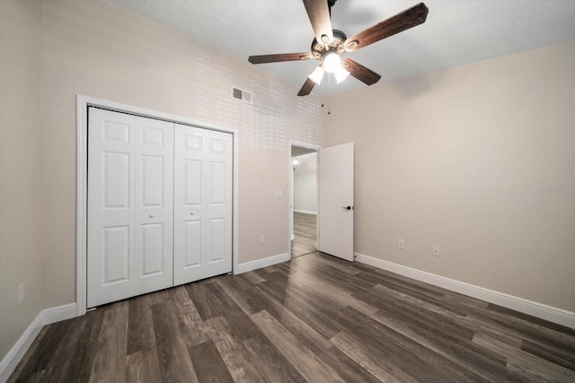 2170 Elm St Unit 906, Dunedin, FL 34698 - unfurnished bedroom with ceiling fan, dark wood finished floors, baseboards, visible vents, and a closet