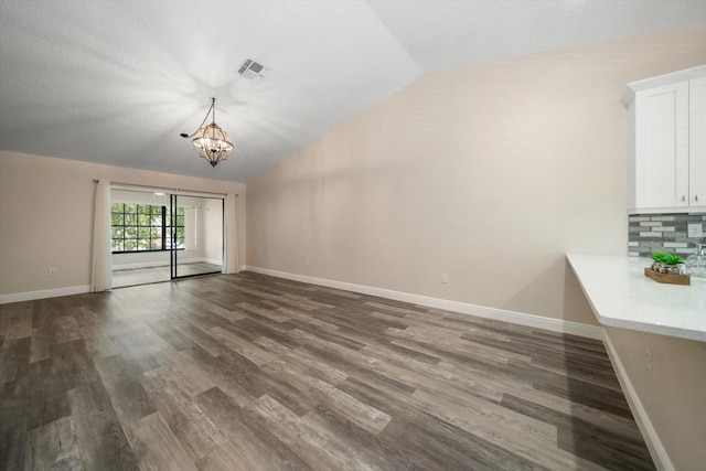 2170 Elm St Unit 906, Dunedin, FL 34698 - unfurnished living room featuring visible vents, lofted ceiling, a chandelier, and dark wood-style floors