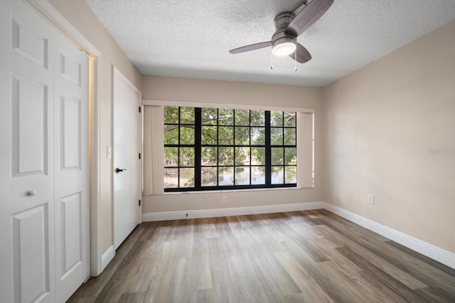 2170 Elm St Unit 906, Dunedin, FL 34698 - unfurnished bedroom featuring a textured ceiling, multiple windows, and wood finished floors