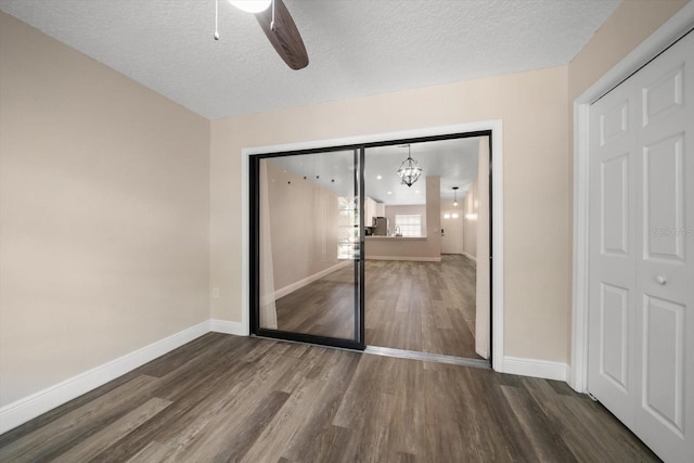 2170 Elm St Unit 906, Dunedin, FL 34698 - unfurnished bedroom with baseboards, a textured ceiling, ceiling fan with notable chandelier, and wood finished floors