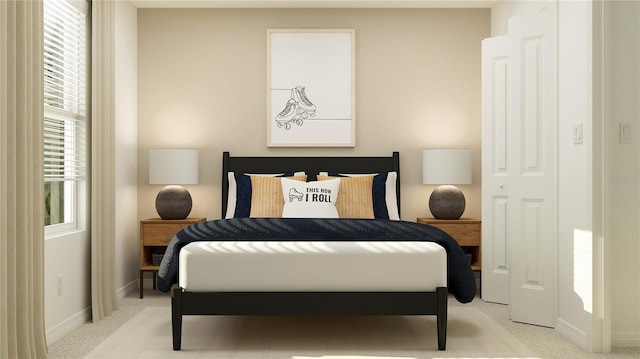 bedroom featuring baseboards and light carpet
