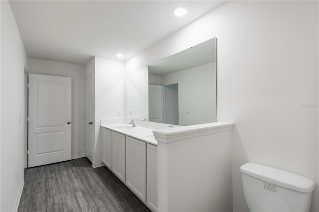 587 Bay Leaf Dr, Poinciana, FL 34759 - bathroom with wood finished floors, vanity, baseboards, toilet, and recessed lighting