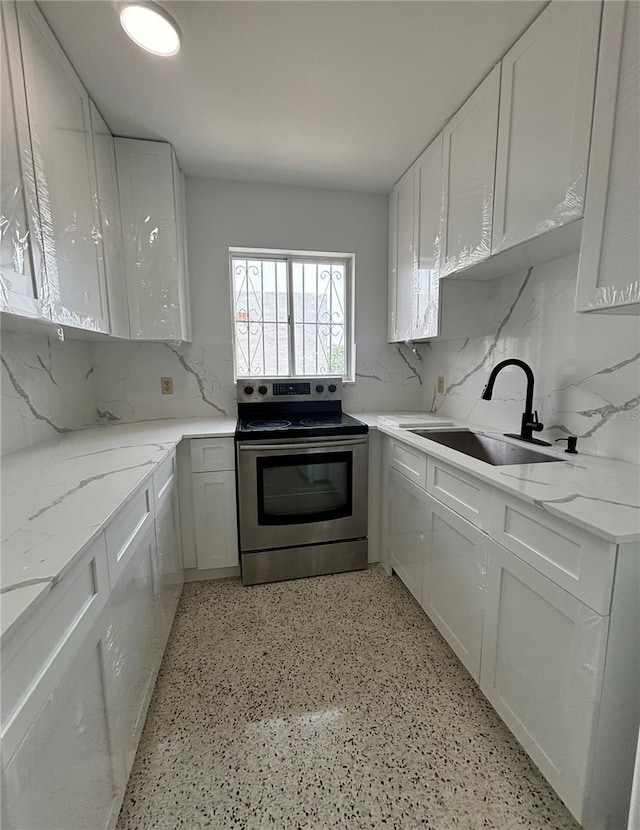 2921 SW 10th St Unit 23, Miami, FL 33135 - kitchen featuring stainless steel electric range, white cabinets, tasteful backsplash, and light stone counters