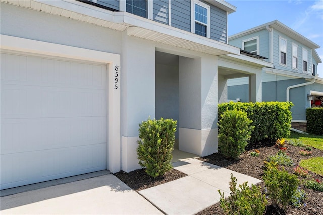 8595 Prairie Creek Dr, New Port Richey, FL 34655 - doorway to property featuring a garage and stucco siding