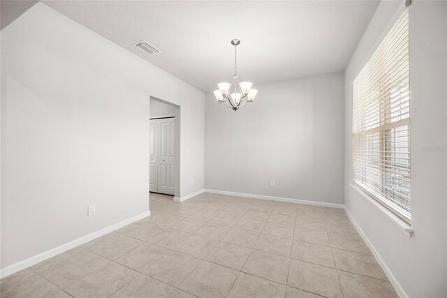 8595 Prairie Creek Dr, New Port Richey, FL 34655 - spare room with a chandelier, light tile patterned flooring, and baseboards
