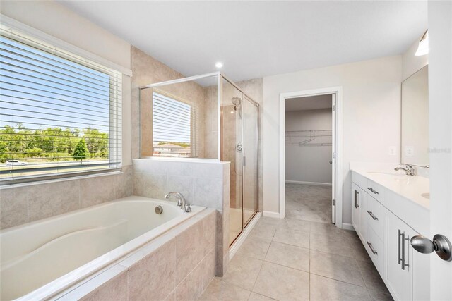 8595 Prairie Creek Dr, New Port Richey, FL 34655 - bathroom with a shower stall, tile patterned flooring, a garden tub, double vanity, and a spacious closet
