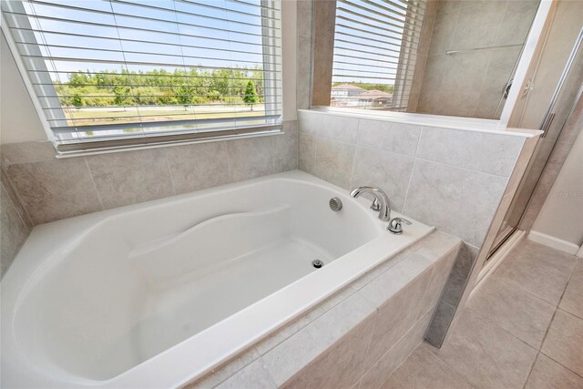 8595 Prairie Creek Dr, New Port Richey, FL 34655 - full bathroom with a shower stall, a bath, and tile patterned floors