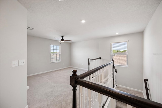 8595 Prairie Creek Dr, New Port Richey, FL 34655 - corridor with an upstairs landing, carpet flooring, baseboards, a textured ceiling, and recessed lighting