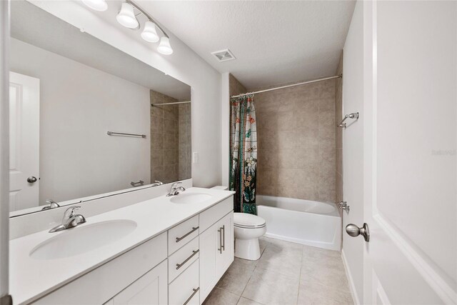 8595 Prairie Creek Dr, New Port Richey, FL 34655 - full bathroom featuring tile patterned flooring, toilet, shower / bath combo with shower curtain, double vanity, and a textured ceiling