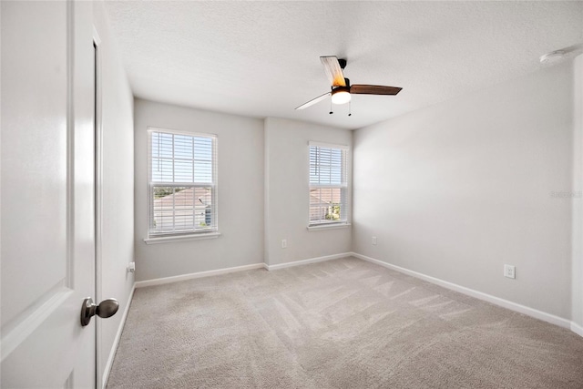 8595 Prairie Creek Dr, New Port Richey, FL 34655 - empty room featuring ceiling fan, plenty of natural light, light colored carpet, baseboards, and a textured ceiling