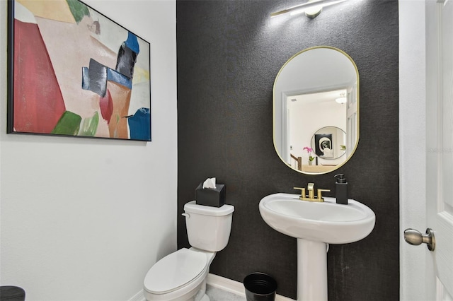 half bath with toilet and baseboards