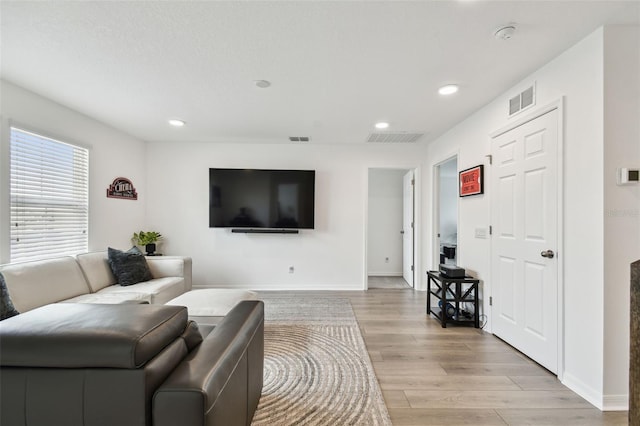 living room with light wood finished floors, recessed lighting, and baseboards