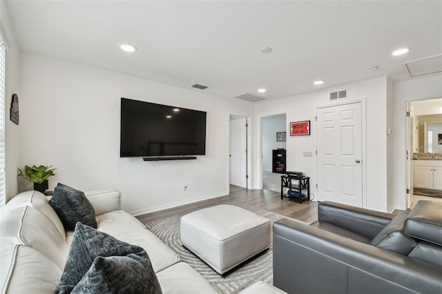 living area with wood finished floors, recessed lighting, and baseboards